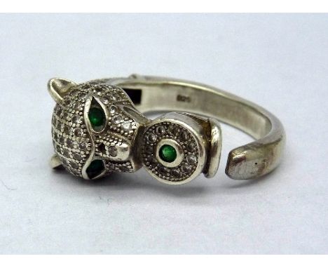 An Art Deco style silver leopard ring with emerald eyes, lacking one stone, size O