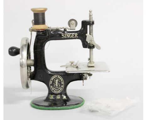 Miniature Singer Sewing Machine, with three reels of cotton, 17cm highMechanism appears to be working.  I am not sure if anyt
