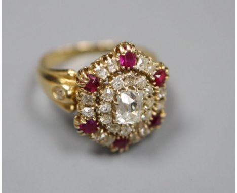 A Victorian style yellow metal ruby and diamond oval cluster ring, with central rectangular cushion cut stone, size L, gross 