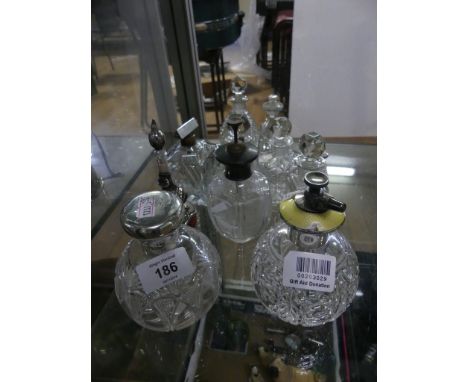 A collection of various cut clear glass scent bottles, some bearing silver mounts 