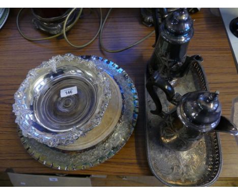 A mixed lot of silver-plated wares comprising bottle stand, bread board, coffee pot, hot water pot and tray 