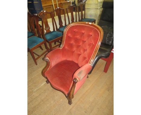 A Victorian armchair with show wood frame, scrolled support and short swept legs, fitted with button upholstery. 
