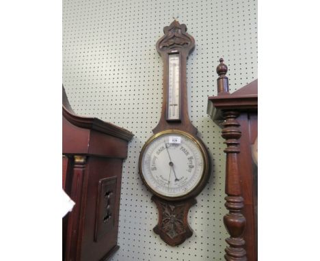 An early 20th Century aneroid barometer/thermometer combination, in carved oak case 