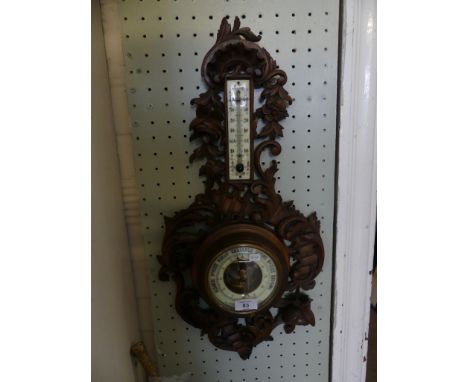 A late 19th Century French aneroid barometer/thermometer combination in pierced wooden foliate frame 