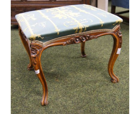 A carved walnut dressing stool with upholstered pad seat