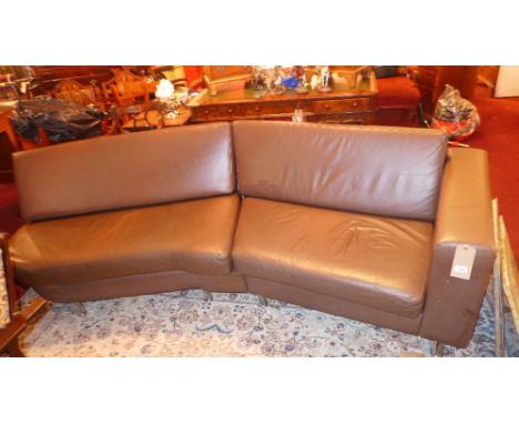 A contemporary four seater reception sofa upholstered in brown leather raised on chromed supports 