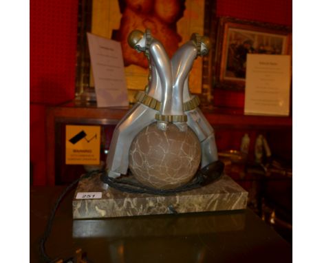 A 20th century Art Deco style table lamp in the form of two clowns with spherical shade on a marble base, marked EXE