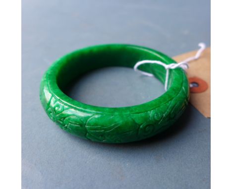 A Chinese jade bangle decorated with carved detail