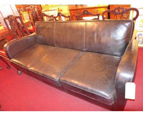 A retro three seater sofa upholstered in black leather and raised on chromed supports 