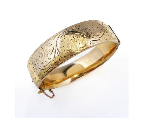 A 9-carat (outer case only) gold bangle with engraved decoration (Please note; this bangle has a metal core), total approx. w