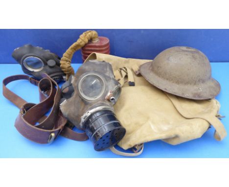 A British Army canvas haversack containing two gas masks, Brodie helmet and Sam Browne leather belt