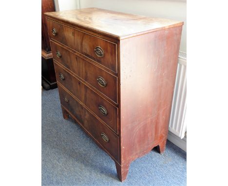 An early 19th century mahogany chest; four full-width graduated drawers with stamped brass ovals, shaped apron and on high Fr