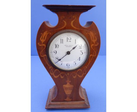 An early 20th century Art Nouveau inspired mantle clock; shaped mahogany case with boxwood marquetry emanating from a vase be