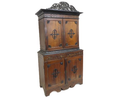 A late 19th / early 20th century continental press cupboard; the pierced cornice ornately decorated with flowerheads above an