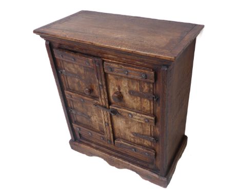 An antique style colonial miniature side cabinet of small proportions; the outset cleated top above two iron bound and panell