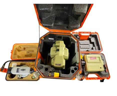 Three cased surveying instruments including two Leica.