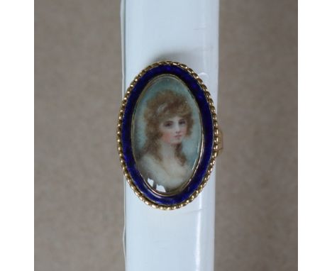 An 18ct gold portrait ring of oval form with blue enamel border painted with the head and shoulders of a young lady, size M, 