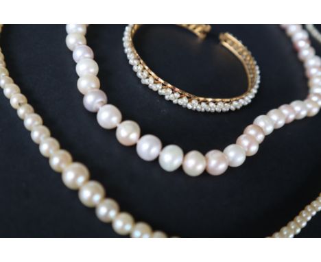 A pearl necklace with graduated beads,to a yellow metal clasp, 64cm long together with another pearl necklace and a seed pear