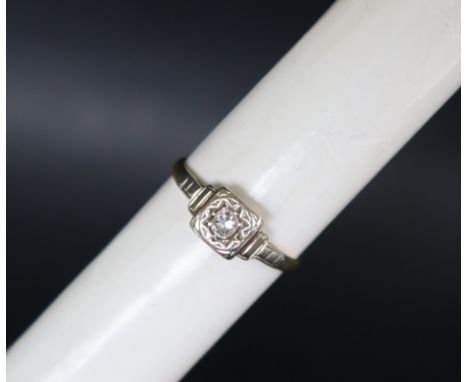 A solitaire diamond ring, set with a round old cut diamond, in a claw and raised border setting to a yellow metal shank marke