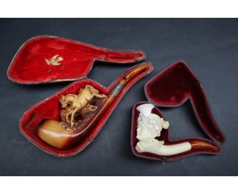 A Meerschaum pipe carved in the form of a maiden in a floral carved bonnet, cased together with another of another carved as 