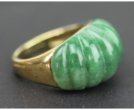 A 9ct yellow gold and jade set dress ring, the carved bombe shaped jade inset into 9ct yellow gold, weight 6.5gms