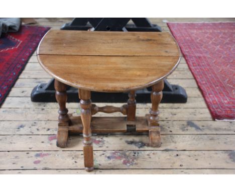 A light oak drop leaf table, on turned legs, 50cm x 60cm 