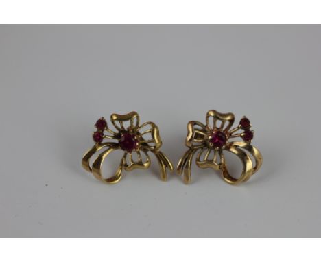 A pair of 9ct gold and ruby set earrings, each designed as bows, 1.75cm wide, weight 3gms