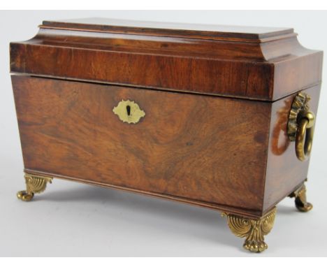 A Regency rosewood tea caddy, hinged lid enclosing two canisters, mixing bowl a/f, with brass loop handles on scroll and paw 