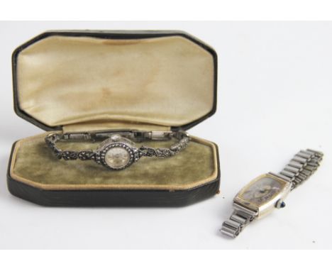 A Lady's Cyma Art Deco wristwatch, the rectangular case enclosing silvered dial, Arabic numerals and stone set winding button