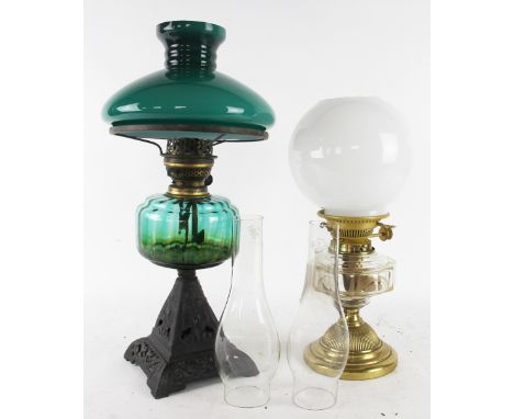 A Victorian Art Nouveau cast iron oil lamp, with green glass reservoir and opaque green glass shade, 53cm; with a brass and c