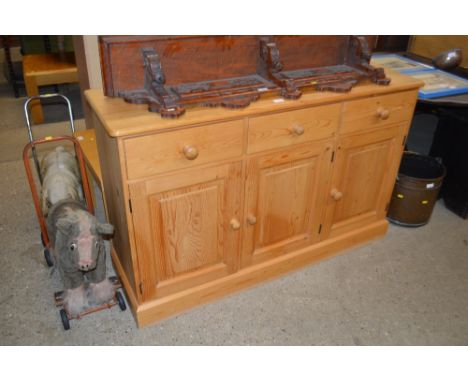 A stripped pine sideboard fitted three drawers