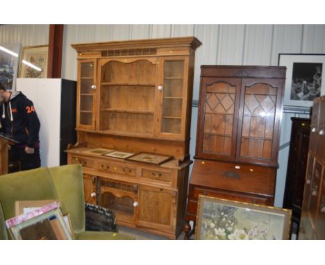A large stripped pine and glazed dresser fitted three drawers and cupboards below 