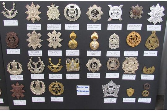 A collection of Scottish Regiment badges mounted on board including ...