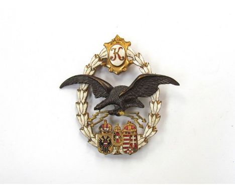 An Imperial era Austrian Air Service personnel badge, the 'K' cartouche with white enamelled wreath to a bronzed eagle carryi