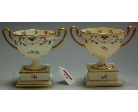 A pair of Mintons soft paste porcelain twin handled pedestal cups, each with gilt and enamel decoration  Condition Report / E