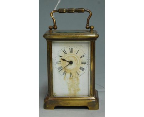 An early 20th century lacquered brass cased carriage clock, having a white enamel dial with Roman numerals and platform lever