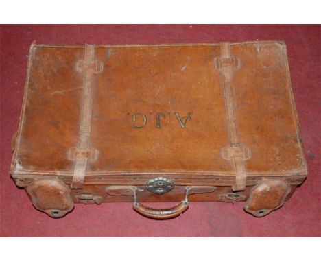 A stitched leather travelling trunk bearing the initials AJG