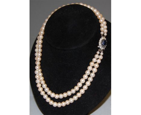 A double string faux pearl choker with paste set clasp