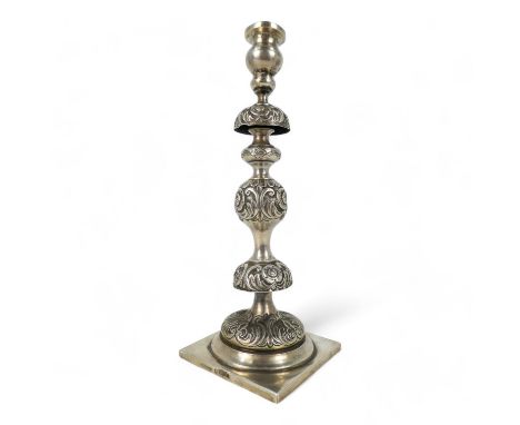 A continental white metal candlestick - probably Russian, of turned form with floral knops, raised on a square base, marks to