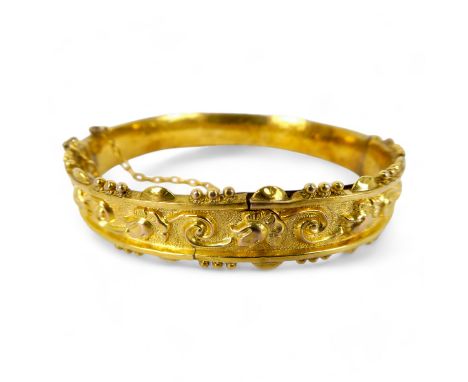 A 9ct gold early 19th century bangle - repousse decorated with flower heads, 11.3g.