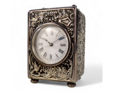 A silver carriage clock - London 1896, with a foliate repousse case, the white circular dial set out with Roman numerals, 8cm