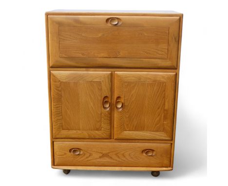 An Ercol elm secretaire - the fall front enclosing an arrangement of shelves above a pair of panel doors and apron drawer, ra