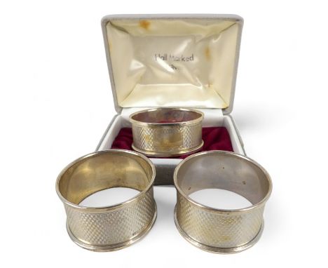 A silver napkin ring - Birmingham 1981, circular with engine turning and vacant cartouche, together with another similar and 