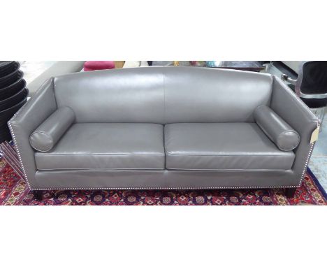 ANDREW MARTIN SOFA, arched back, in grey leather, with two bolster cushions and chrome studded detail, 208cm L x 92cm W x 79c