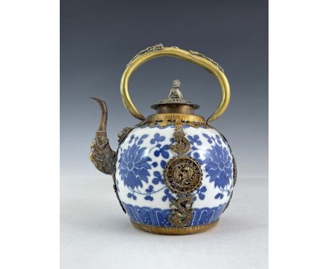 A Chinese blue and white porcelain teapot, of ovoid form with gilt metal loop handle, spout and mounts, the body with floral 
