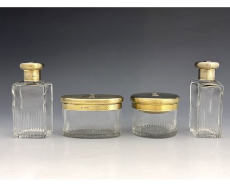 A set of four George V silver gilt cut glass jars, AP, London 1932, the colourless bottles and pots with flame cut decoration