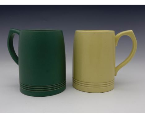 Keith Murray for Wedgwood, two Art Deco beer mugs or tankards, circa 1934, one in matt green, the other in semi-gloss straw, 