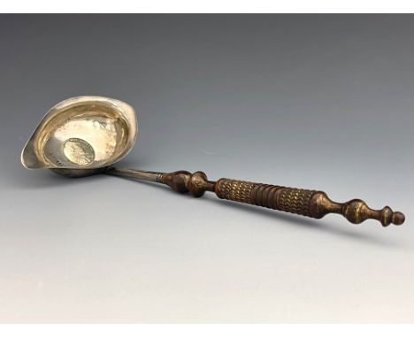 A George III silver coin set ladle, Josiah Snatt, London 1804, pap boat form bowl set with a 1787 shilling, on a turned and c