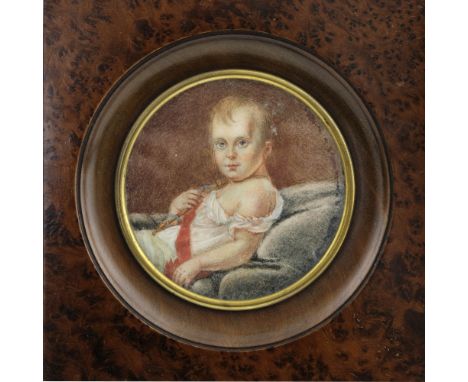 A 19th Century circular portrait miniature of an infant, reclining wearing a red sash, 10cm diameter, framed 