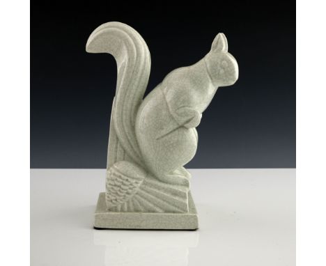 Charles Lemenceau, an Art Deco ceramic figure of a squirrel, modelled sitting on a stylised pine cone, cream craquelure glaze